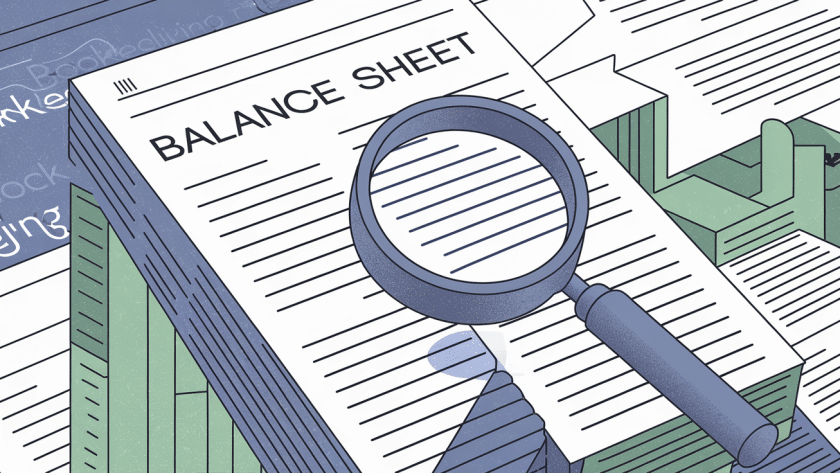 A magnifying glass examining a balance sheet.