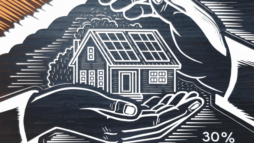 A house with solar panels being protected by a large hand.